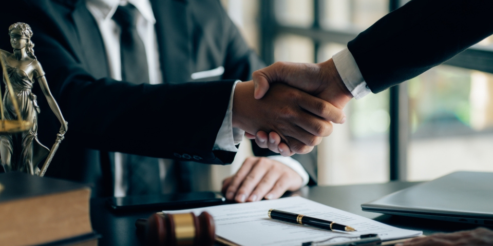 Businessman shaking hands to seal a deal with his partner lawyers or attorneys discussing a contract agreement.Legal law, advice, and justice concept.